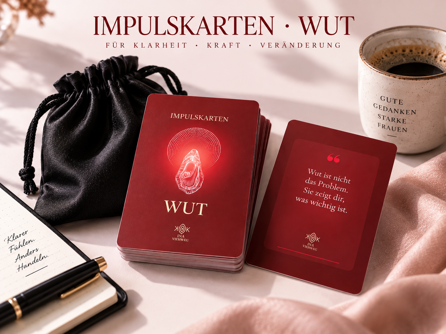 Rote Kartenstapel „WUT“ und „Impulskarten“ neben schwarzem Beutel, Kaffee und Notizbuch auf hellem Tisch.